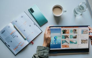 person using Windows 11 computer beside white ceramic mug on white table