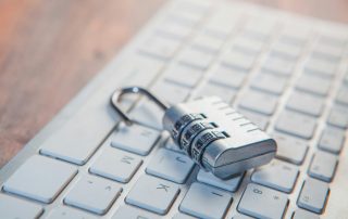 A combination lock rests on a computer keyboard.