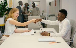 Free Business professionals completing a successful deal with a handshake in a modern office setting. Stock Photo